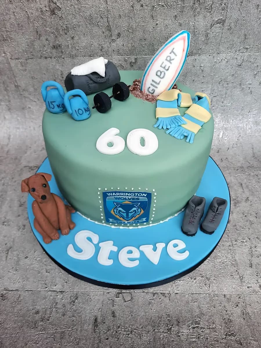 60th birthday cake decorated with hobbies including gym, rugby, dog, and Warrington Wolves