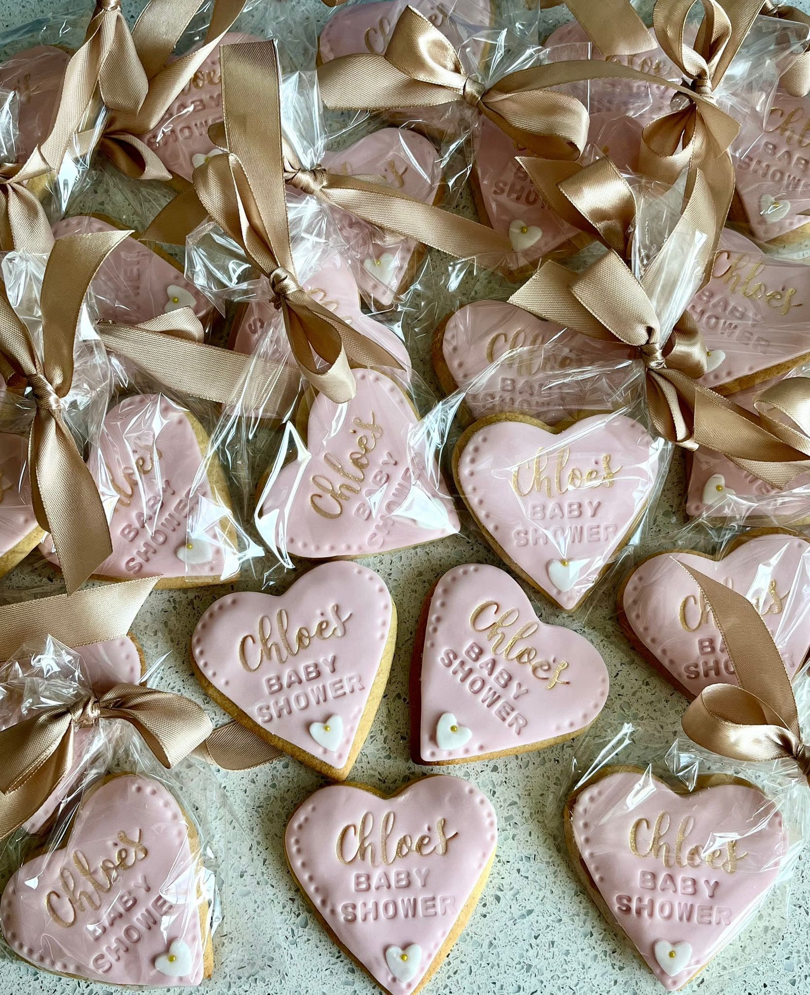 Pink heart baby shower iced biscuits with gold ribbon