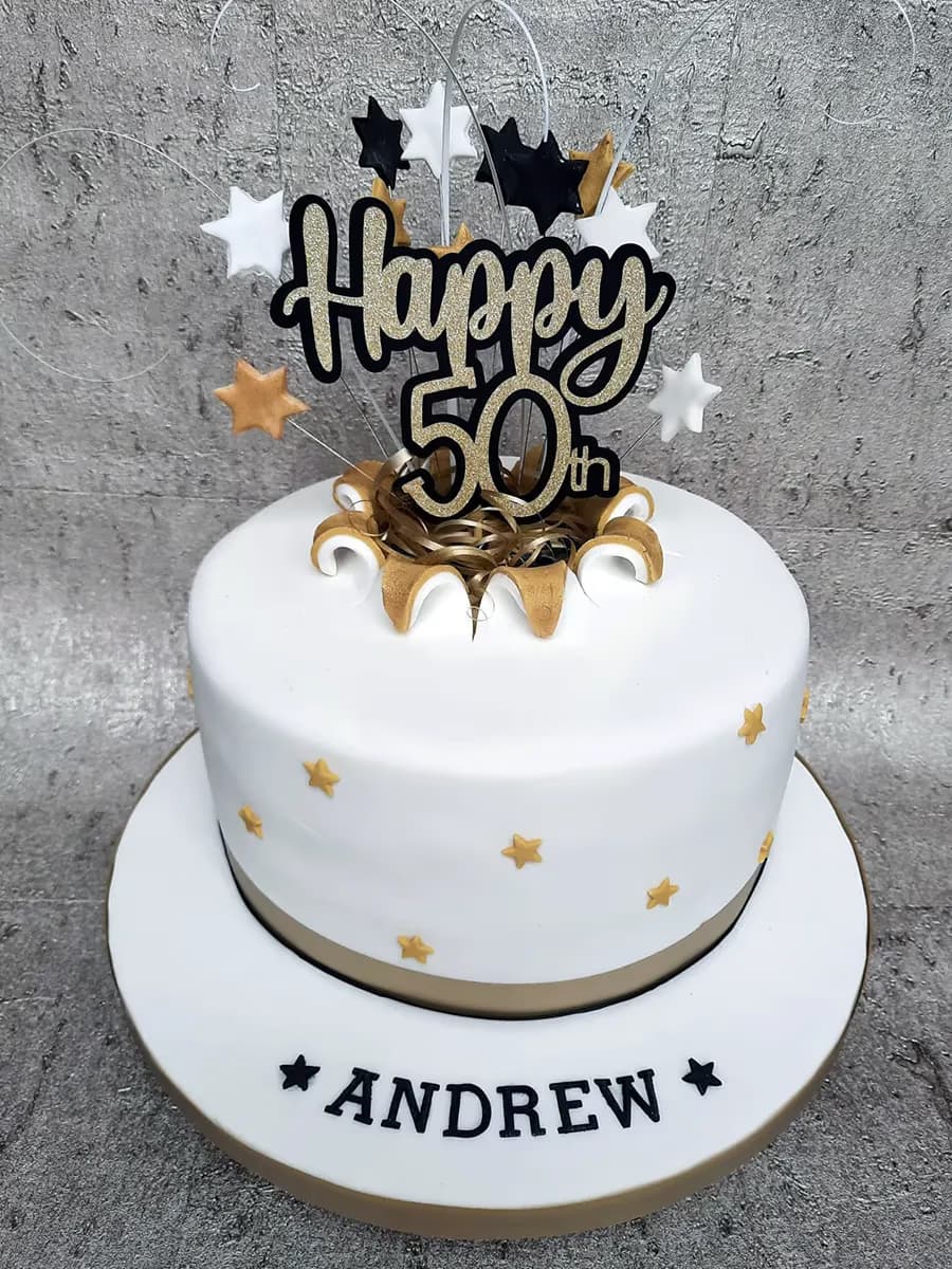50th birthday cake in white, gold, and black with star decoration