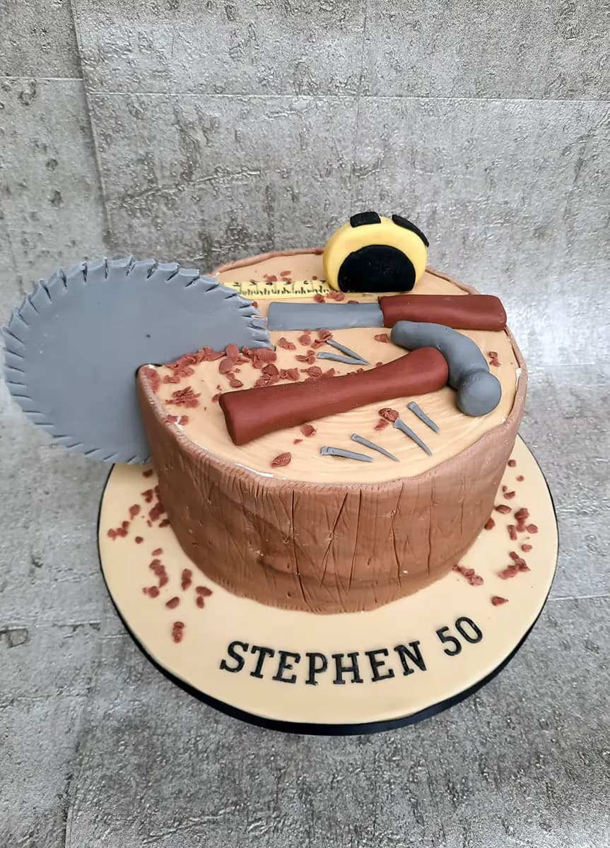 50th birthday cake shaped as a tree stump with carpentry tools decoration