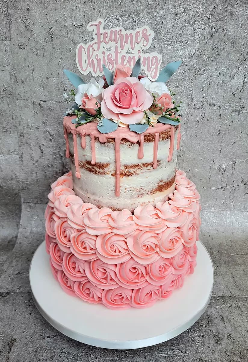 Two-tier semi-naked christening cake with pink drip and roses