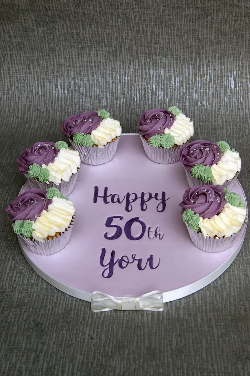 Purple and cream rose cupcakes for a 50th birthday by Thelwall Bakehouse