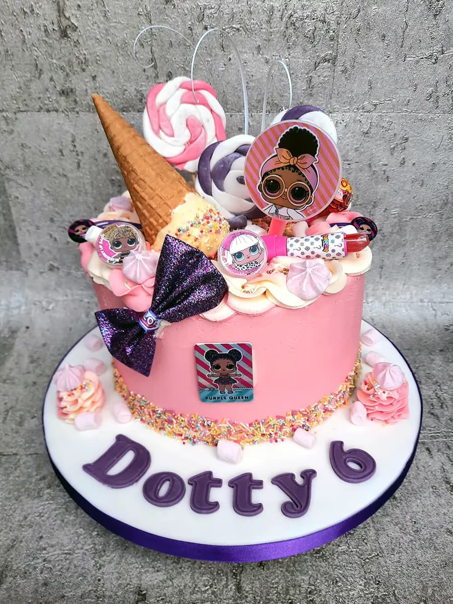 A vibrant pink LOL Surprise doll themed birthday cake, topped with an ice cream cone, pink and purple lollipops, meringues, and various doll toppers, decorated with rainbow sprinkles, a purple glitter bow, and a Purple Queen doll cutout, with 'Dotty 6' written in purple letters on the white cake board.