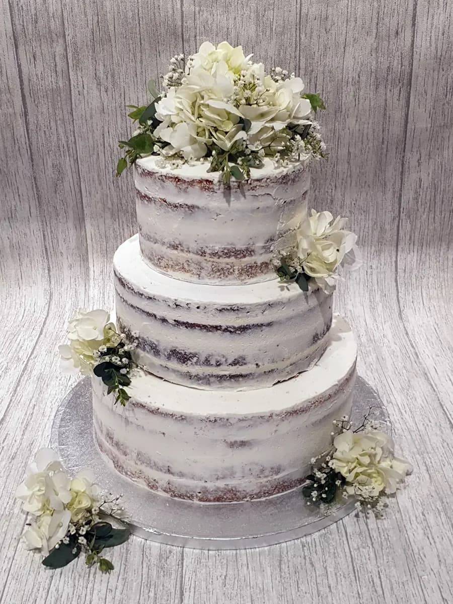 Three-tier wedding cake with ribbon detail by Thelwall Bakehouse