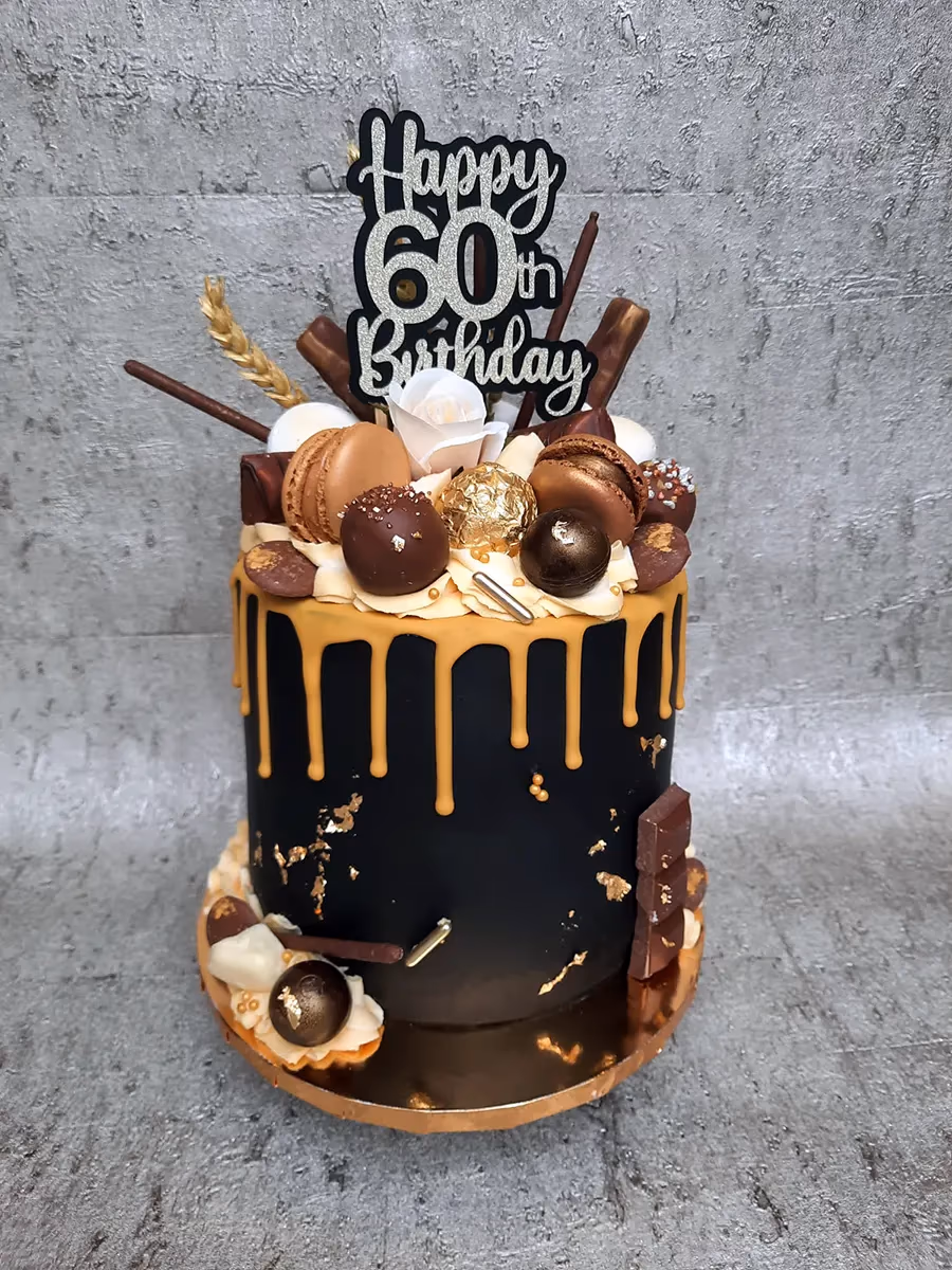 Black and gold drip 60th birthday cake with macarons and chocolates