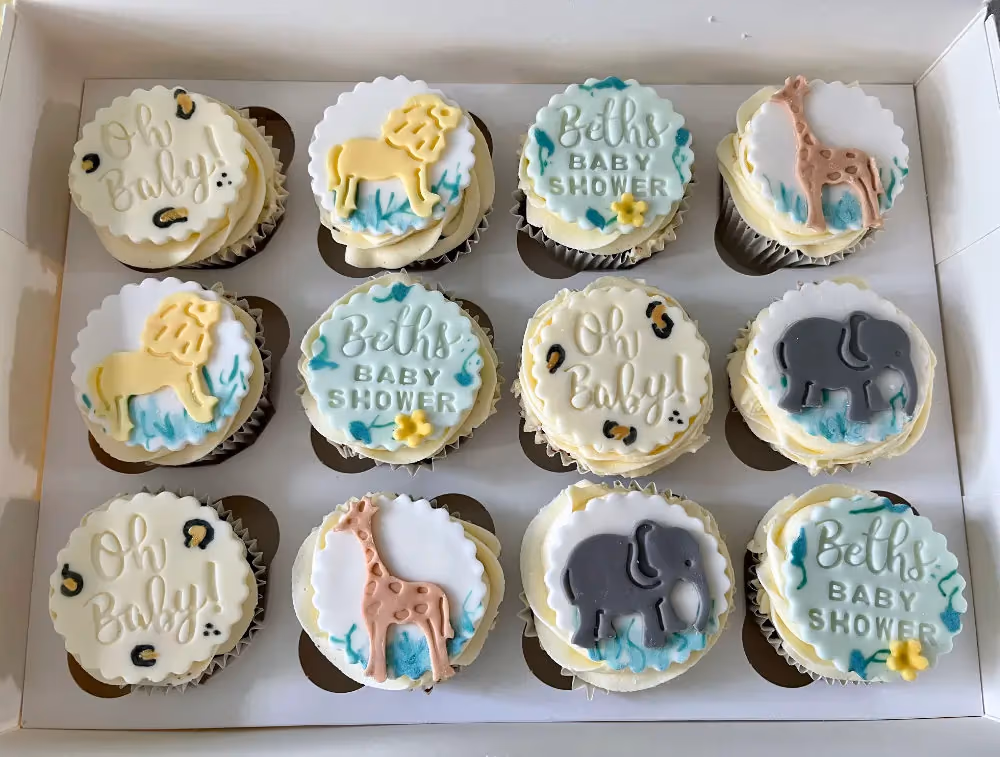 Baby shower cupcakes with safari animal designs by Thelwall Bakehouse