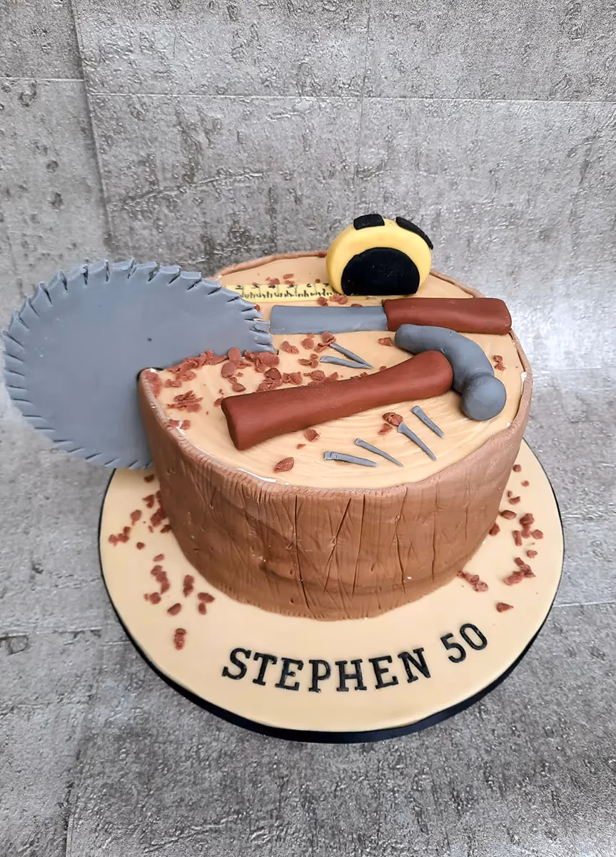 50th birthday cake shaped as a tree stump with carpentry tools decoration