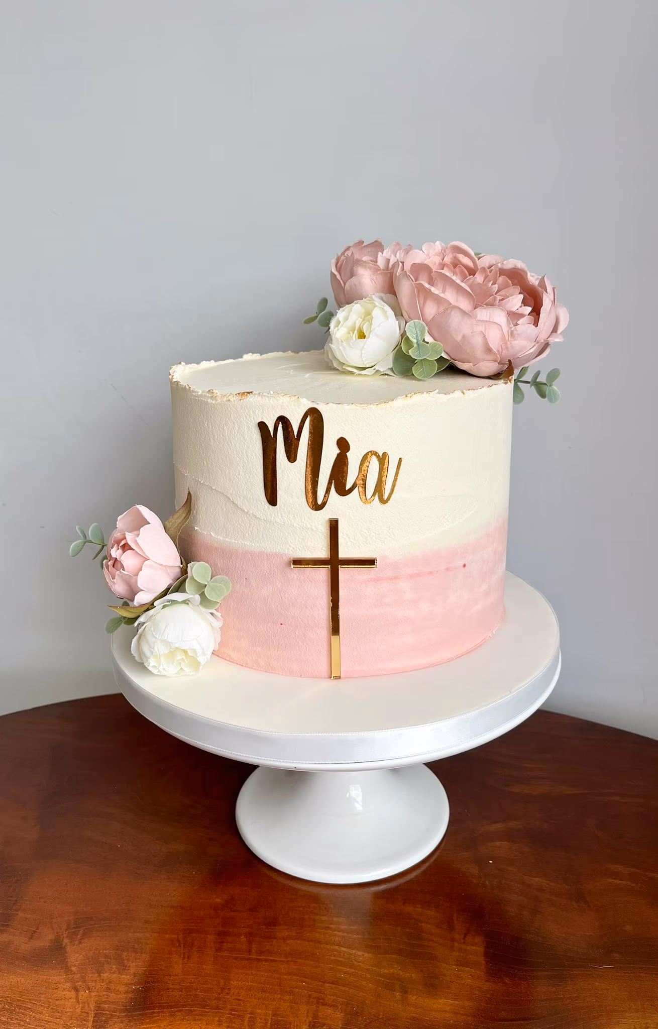 Christening cake with pink white and gold cross and peonies