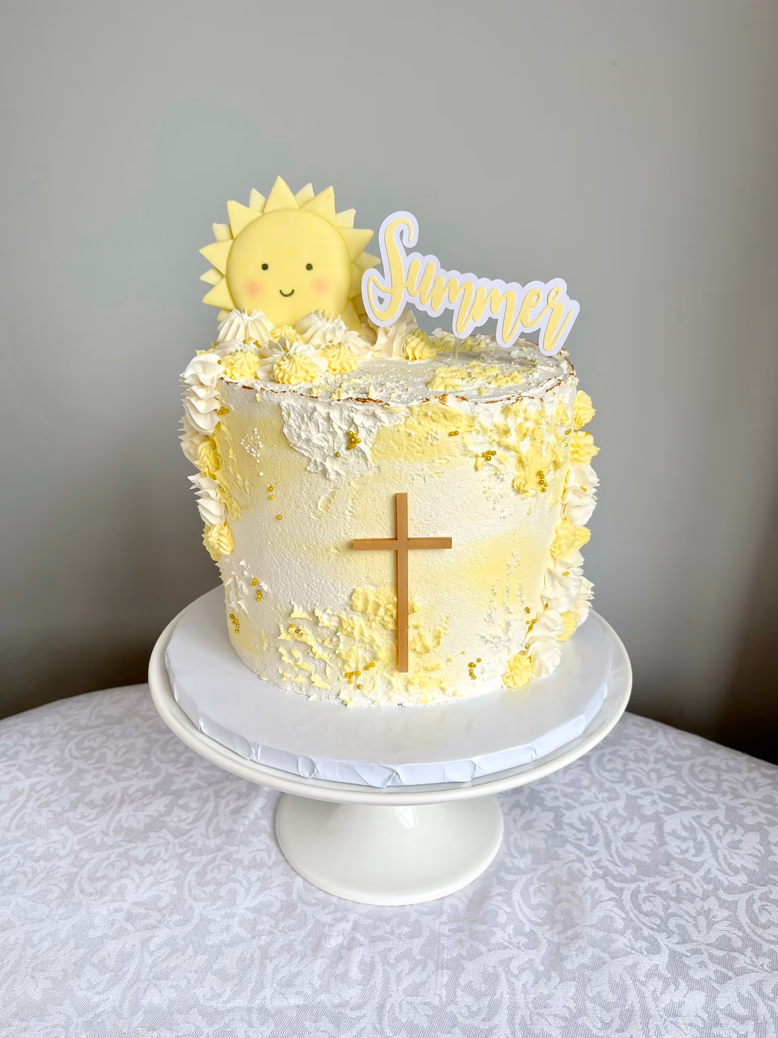 Christening cake with yellow and white sun and cross