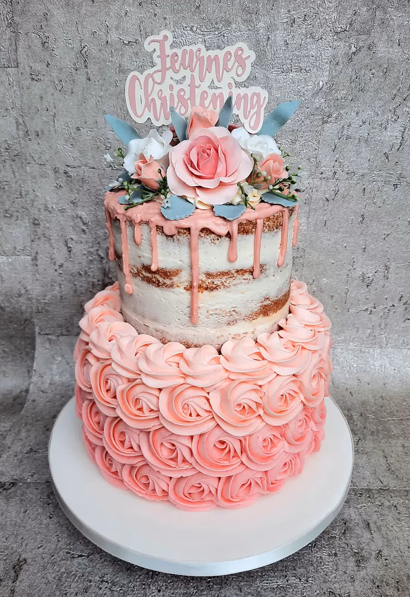 Two-tier semi-naked christening cake with pink drip and roses