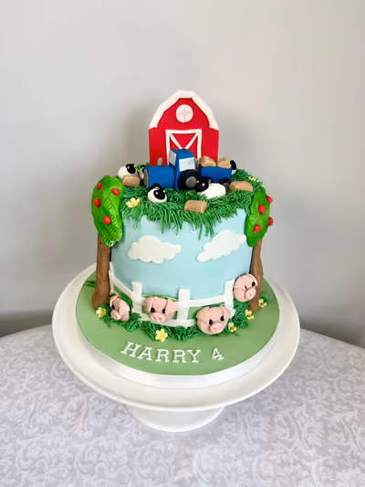 A farm themed 4th birthday cake for Harry with a red barn, a blue tractor, sheep and hay bales on a grassy top, and pigs, apple trees and a white fence around a sky-blue side.