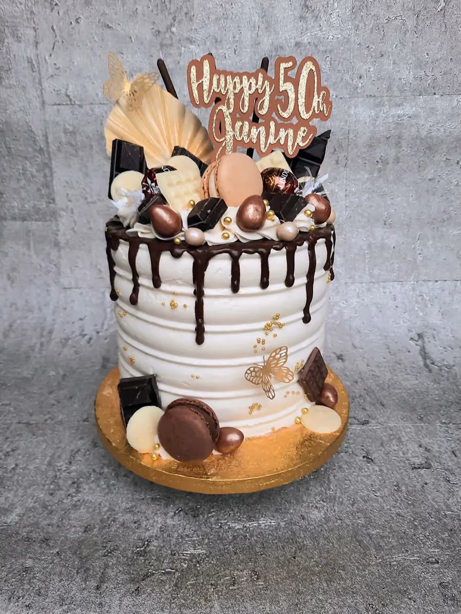 50th birthday chocolate drip cake with macarons and gold butterflies