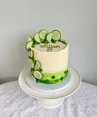 A tall white and green buttercream 8th birthday cake for William, decorated with a cascade of fresh lime slices.