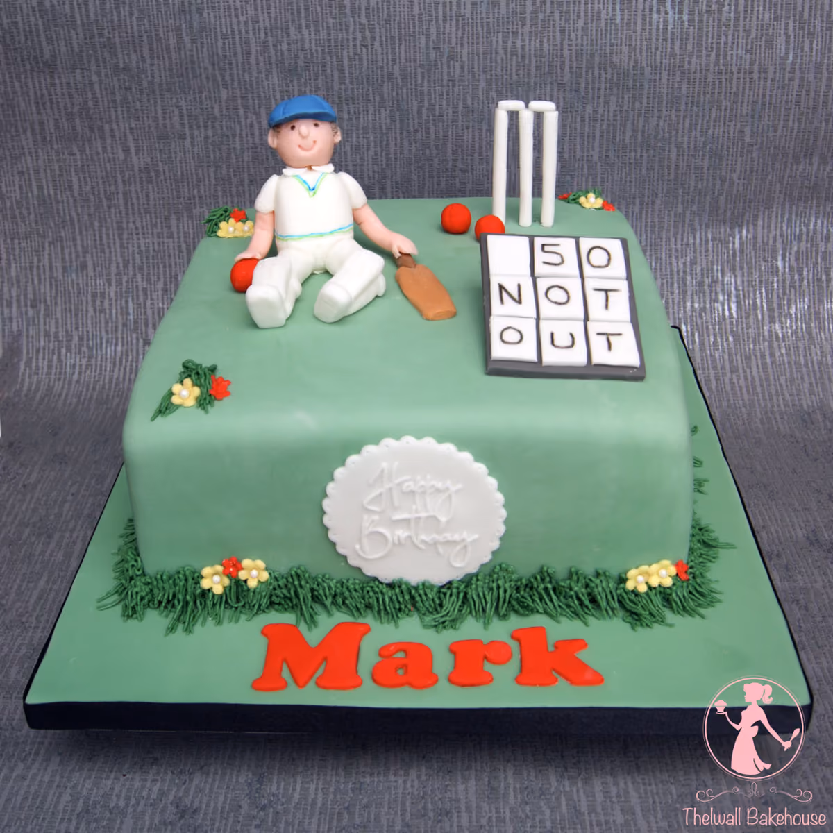 Cricket themed 50th birthday cake with a batsman figure and '50 not out' scoreboard
