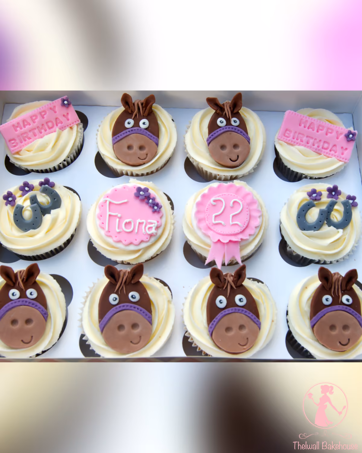 A dozen horse-themed birthday cupcakes in a white box. Six cupcakes feature brown horse faces with purple bridles, two have grey horseshoes with small purple flowers, two have pink rectangular 'Happy Birthday' plaques, one has a pink round plaque with 'Fiona' written in white, and one has a pink rosette with the number '22' in white.