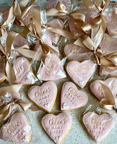 Pink heart baby shower iced biscuits with gold ribbon